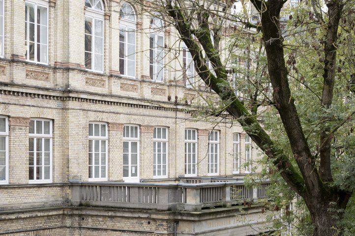 Historic brick building on Dechanatstraße housing the Music Department of HfK Bremen, partially obscured by trees.
