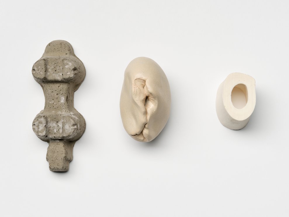 Elements of our living environment as building blocks for a human sculpture (from left to right): Concrete cast of a lamp packaging, unfired, painted clay, leg bones of a lamb.