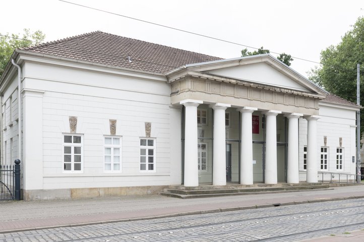 View of the Gerhard-Marcks House, a neoclassical building with columns and signs on the façade.