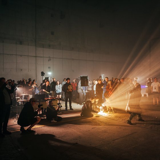 Eine Performance im Bunker Valentin mit Musikern und Publikum, beleuchtet von dramatischem Licht.