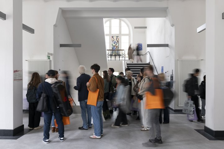 Hallway inside the Dechanatstraße building, HfK Bremen's Music Department, with students gathered and walking around.